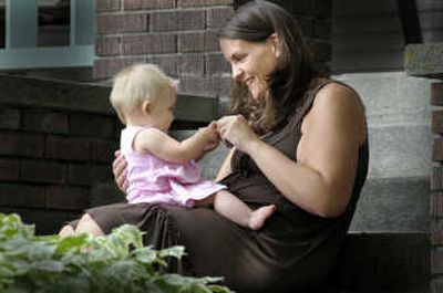 Andrea Kennedy sits with her daughter, Jocelyn, on the front steps of their Spokane home. Kennedy is a doula, also known as a birth companion or assistant. Doulas are professionals who have been trained to nurture and care for mothers during and after childbirth.
 (CHRISTOPHER ANDERSON / The Spokesman-Review)