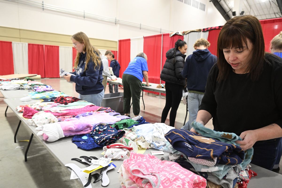 Shelbie Clement, right, helps to sort donated pajamas with other volunteers Monday, Dec. 9, 2024 at the Spokane Fair and Expo Center as the staff prepares for the opening of the annual Christmas Bureau, a effort of Catholic Charities, The Spokesman-Review and Volunteers of America to give a new toy and a book to each child and a grocery voucher to each family. Pajamas are a recent addition to the gift lineup and the supply will only last part of the Bureau’s run. Clement is a nurse at Providence Holy Family Hospital and some of the donations come from hospital staff.  (Jesse Tinsley/THE SPOKESMAN-REVIEW)