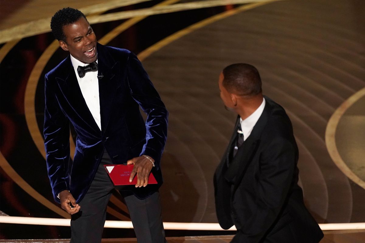Presenter Chris Rock, left, reacts after being hit on stage by Will Smith while presenting the award for best documentary feature at the Oscars on March 27 at the Dolby Theatre in Los Angeles.  (Chris Pizzello)