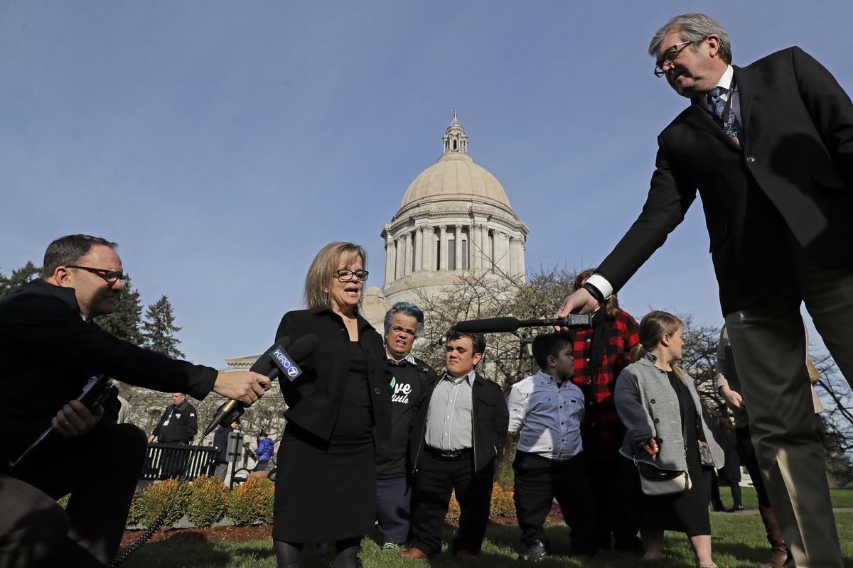 Shoshana Kehoe-Ehlers, second from left, talks to reporters Jan. 31, outside the Capitol in Olympia after a hearing before the Senate Law and Justice Committee of the Washington Legislature to discuss a proposed statewide ban on risky entertainment events, including dwarf tossing, that feature people with dwarfism. (Ted S. Warren / Associated Press)