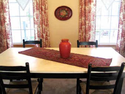 
An old work table from the Northwest Museum of Arts and Culture and vintage linen tablecloths hung as valances find new life in the dining room. 
 (Cheryl-Anne Millsap / The Spokesman-Review)