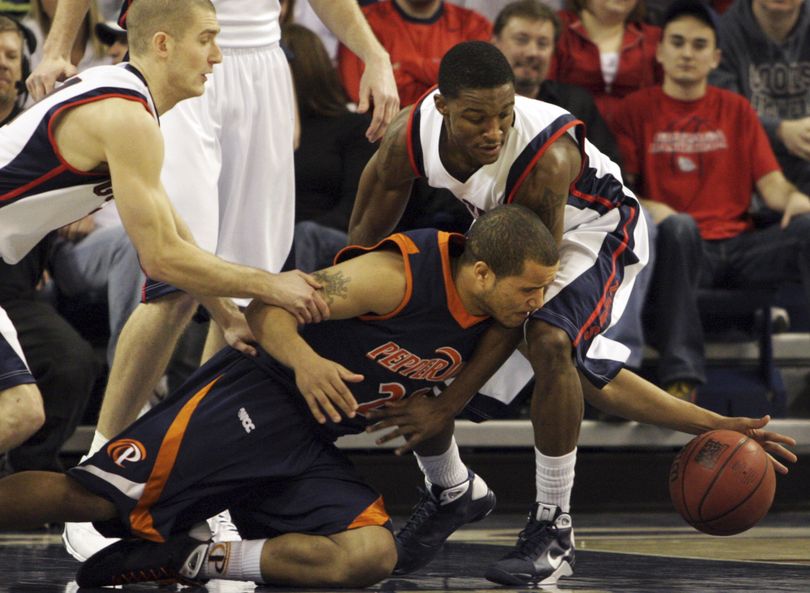 Pepperdine's Lorne Jackson battles Gonzaga's Andrew Sorenson, left, and Demetri Goodson, right, for a loose ball. (Rajah Bose / Associated Press)