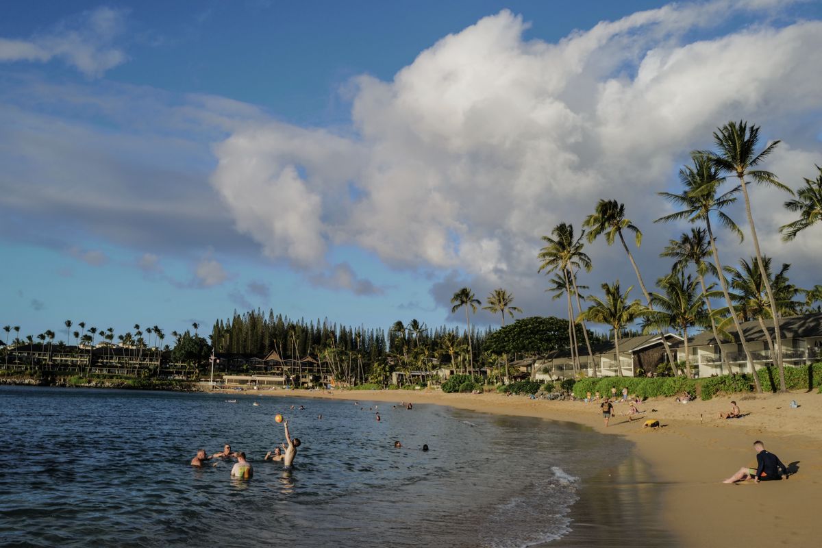 Beachgoers enjoy the sea on a near empty beach in Napili, Hawaii, on Oct. 9, the day after the tourism reopening in West Maui.  (Michael Robinson Chávez/Washington Post)