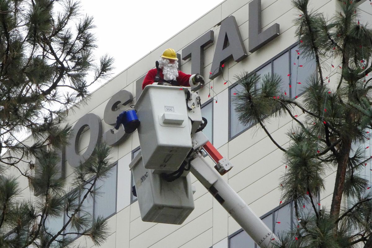 Linemen from Avista Utilities, one dressed as Santa Claus, string lights on trees in Cowley Park, just outside the Providence Sacred Heart Children’s Hospital, Monday, Nov. 21, 2016. The utility workers had assistance from other contractors who donate their time to the KXLY Extreme Team, which is making over the small park with lights this week. (Jesse Tinsley / The Spokesman-Review)