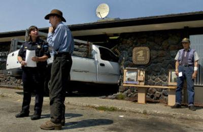 
 Antone Matthew Trampus , 88, center, tells Lt. Tomi McLean of the Rathdrum Police Department how his truck ended up crashing through the Rathdrum Post Office on Monday, as Stan Hammond, far right, of Rathdrum, waits to mail his letters. 
 (Kathy Plonka / The Spokesman-Review)