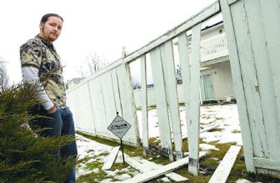 
Greg Wilcox, who caught two men burglarizing his home, stands by a hole in the fence through which he says the two fled, running to a nearby house. 
 (J. BART RAYNIAK / The Spokesman-Review)