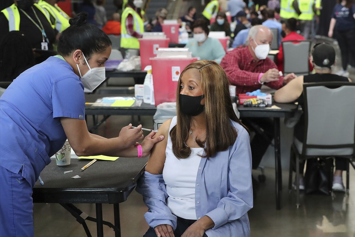 FILE - In this March 23, 2021, file photo, Anita Shetty, left, vaccinates Doris Lucas with a Pfizer vaccine in Atlanta. More than three months into the U.S. vaccination drive, many of the numbers paint an increasingly encouraging picture as dozens of states have thrown open vaccinations to all adults or are planning to do so in a matter of weeks. (Curtis Compton)