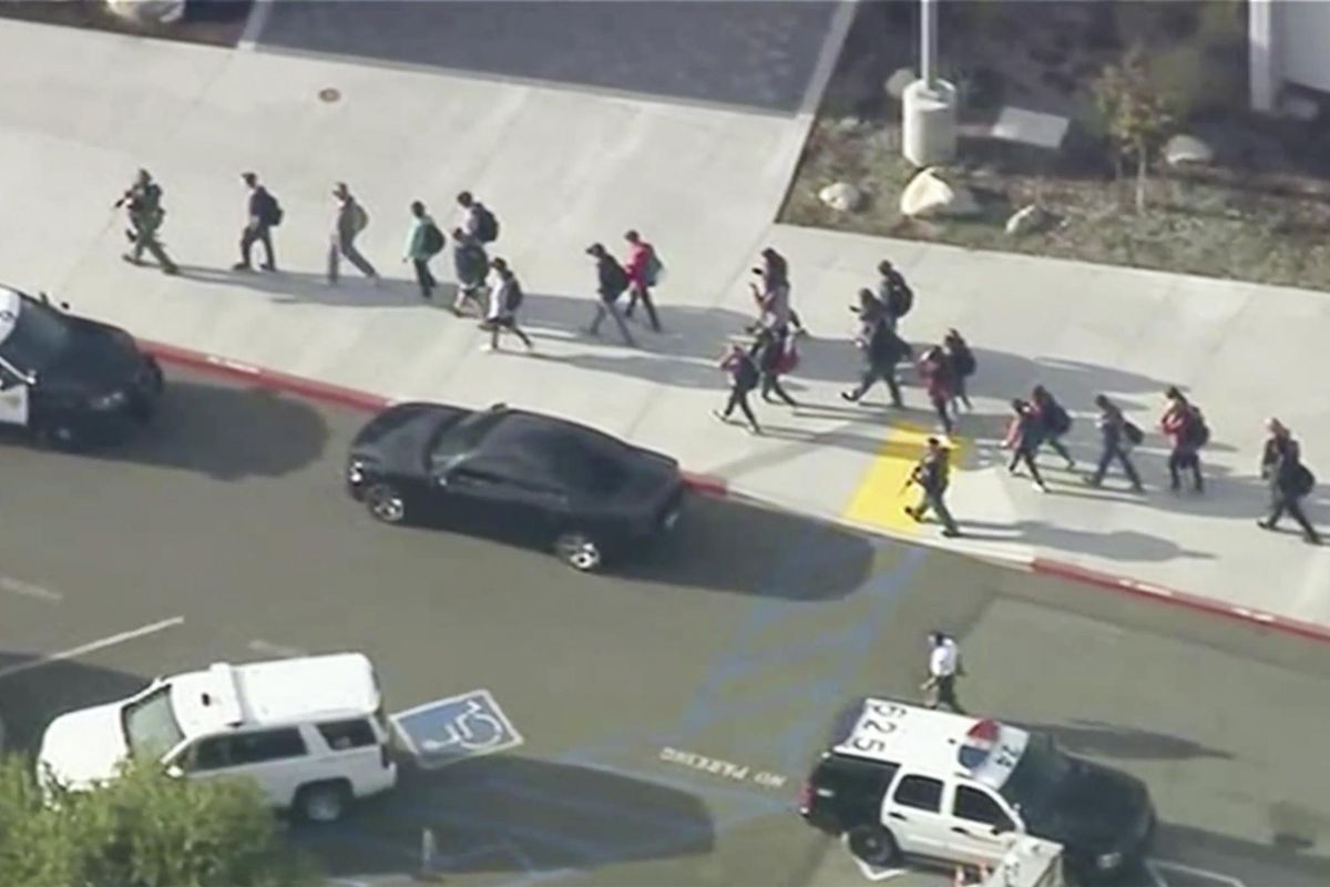 People are lead out of Saugus High School after reports of a shooting on Thursday, Nov. 14, 2019 in Santa Clarita, Calif. The Los Angeles County Sheriff’s Department says on Twitter that deputies are responding to the high school about 30 miles northwest of downtown Los Angeles. The sheriff’s office says a male suspect in black clothing was seen at the school. (KTTV-TV via AP)