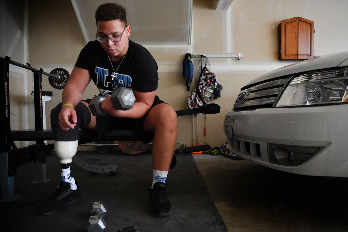 Central Valley football’s Brandon Thomas works out in his garage gym on Friday in Liberty Lake. Thomas had his right leg amputated a year ago after being diagnosed with a form of bone cancer and is working his way back to the field.  (Tyler Tjomsland/The Spokesman-Re)