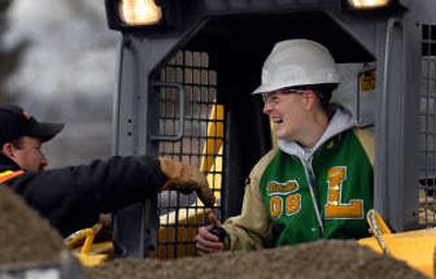 Lakeland High School senior Melissa Phillips takes instruction from Justin Whitmore, of H&E Equipment out of Coeur d'Alene, at Tuesday's