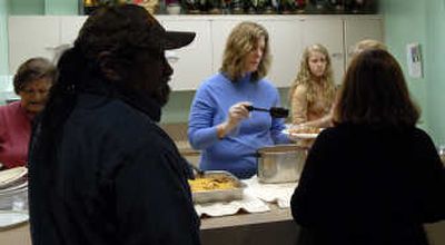 
Janet Single-Schwall, center, along with her daughter Rachael, 13, serve lunch at First Presbyterian Church Ecumenical Food Kitchen on Jan. 31. 
 (Kathy Plonka / The Spokesman-Review)