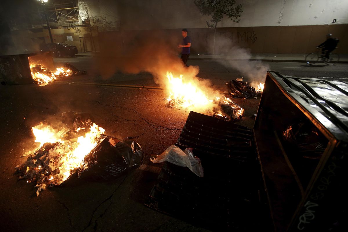 Multiple fires are lit in dumpsters and trash cans during protests in downtown Oakland, Calif., late Tuesday, Nov. 8, 2016. (Jane Tyska / Associated Press)