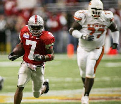 
Ohio State receiver Ted Ginn Jr. runs upfield with a reception as Oklahoma State defender Walter Thomas pursues.
 (Associated Press / The Spokesman-Review)