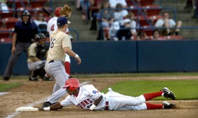 
Spokane's Julio Santana is safe at first after a pickoff attempt by Tri-City pitcher David Patton during the third inning of Friday's game.
 (Holly Pickett / The Spokesman-Review)