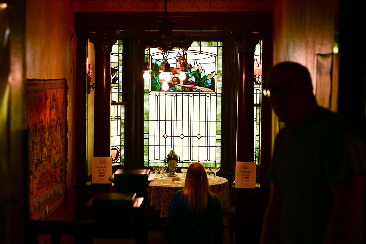 Estate sale goers check out stained glass windows and antique furniture during an estate sale at Mary