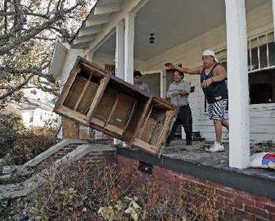
Workers throw out furniture from a home which was flooded during Hurricane Katrina in East Biloxi, on Tuesday.
 (Associated Press / The Spokesman-Review)