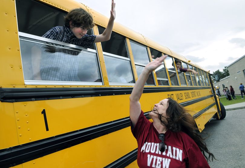 Bittersweet bon voyage: Mountain View Middle School fitness and health teacher Cathy Inouye high-fives student Brendan Schuller as the last bus leaves on the last day of school on Friday in Newman Lake. The school is closing after 32 years. The East Valley School District is moving toward a kindergarten through eighth grade system and will close its other middle school in two years. (Dan Pelle)