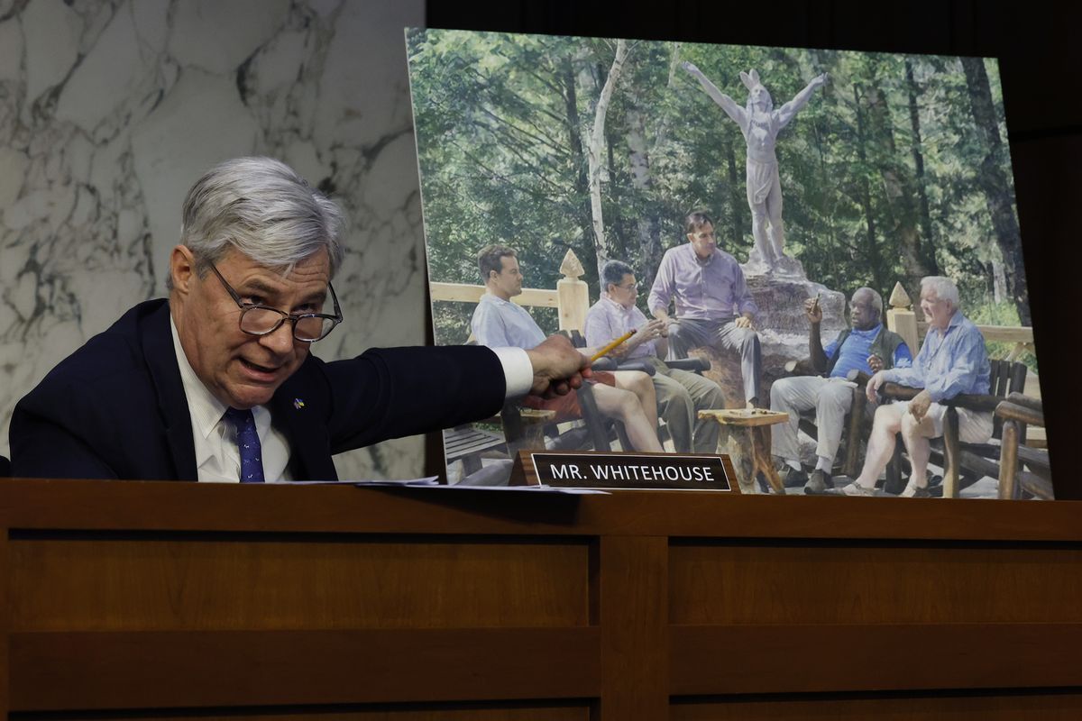 Senate Judiciary Committee member Sen. Sheldon Whitehouse (D-R.I.) displays a copy of a painting commissioned by Texas billionaire Harlan Crow featuring Supreme Court Associate Justice Clarence Thomas alongside other conservative leaders during a hearing on Supreme Court ethics reform in the Hart Senate Office Building on Capitol Hill on May 2 in Washington, D.C.  (Chip Somodevilla)