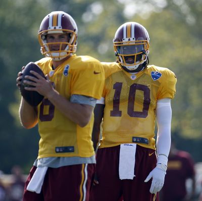 Redskins coach Jay Gruden named Kirk Cousins, left, the 2015 starter as Robert Griffin III, right, awaits his fate. (Associated Press)