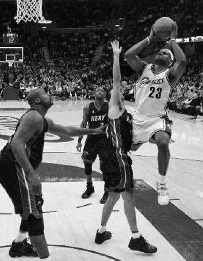 
Cleveland Cavaliers' LeBron James (23) shoots over Miami Heat's Jason Kapono as Heat's Shaquille O'Neal, left, watches during the second quarter. 
 (Associated Press / The Spokesman-Review)