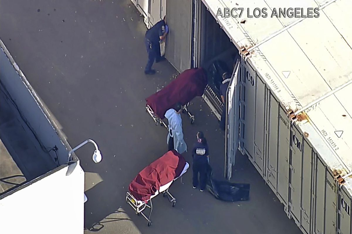 This file photo from video provided by ABC7 Los Angeles shows workers putting bodies into a refrigerated trailer at the offices of the Los Angeles County Coroner in Los Angeles. More than 500 people are dying each day in California because of the coronavirus. The death toll has prompted state officials to send more refrigerated trailers to local governments to act as makeshift morgues. State officials said Friday they have helped distribute 98 refrigerated trailers to help county coroners store dead bodies.  (TEL/Associated Press)