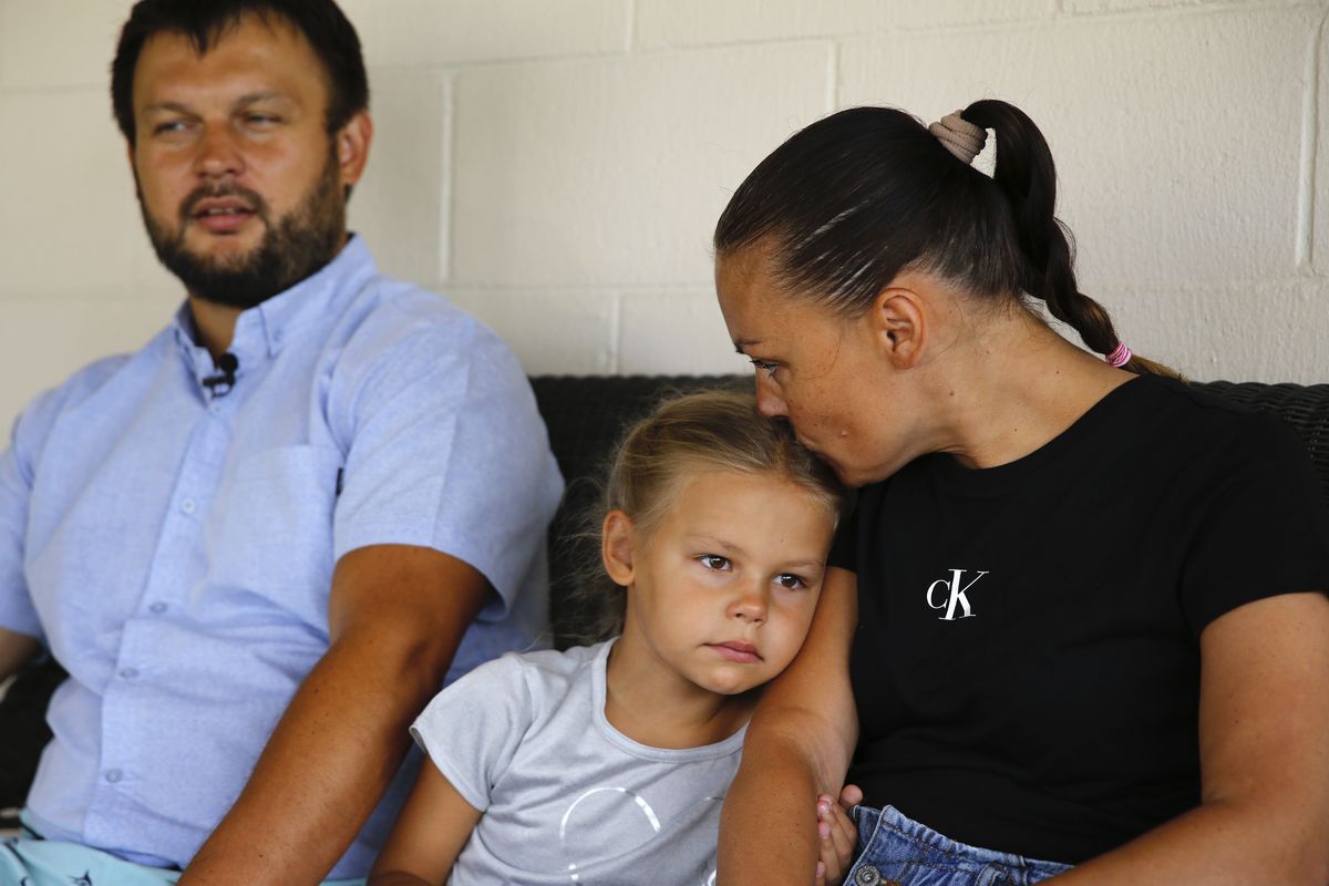 Vasyl Prishchak, left, is interviewed by The Associated Press as his wife, Marina, right, and daughter, Ksenia, 5, sit next to him at their temporary home in Kailua, Hawaii, Wednesday, March 23, 2022. The Prishchak family travelled to Hawaii for a long-awaited vacation on Feb. 16 and planned to return to Ukraine on March 7. But a week into their vacation, Russia invaded their country, leaving the family in shocked disbelief with no access to family, friends, money or their home.  (Caleb Jones)