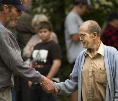 
Edwin Link, right, receives condolences from neighbors. He doesn't carry insurance. 
 (The Spokesman-Review)