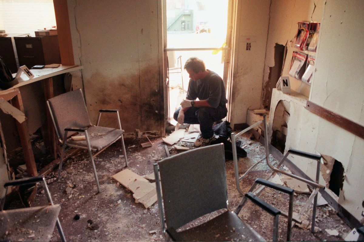 Federal agent Lance Hart kneels in the doorway to the lobby of the Planned Parenthood clinic in this July 13, 1996 photo. Four North Idaho men with ties to a white supremacist religious group bombed the clinic before robbing a bank. (SR)