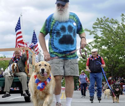 Jon Busath, of Coeur d’Alene, a member of the Kootenai County Dog Park Association, walks his golden retriever, Molly, in the American Heroes Parade in Coeur d’Alene on Sunday to support  the off-leash park  scheduled to open just after Labor Day.  (J. BART RAYNIAK)