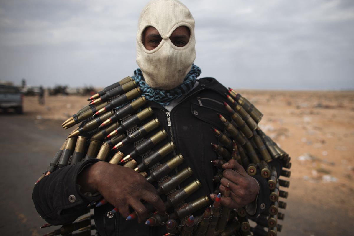A volunteer carries ammunition near Ras Lanouf, Libya. Government forces drove hundreds of rebels from a strategic oil port on Thursday. (Associated Press)