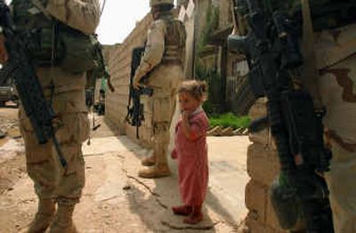 
An Iraqi girl is surrounded by U.S. soldiers in front of her house Wednesday in Hawija, 150 miles north of Baghdad, Iraq. 
 (Associated Press / The Spokesman-Review)