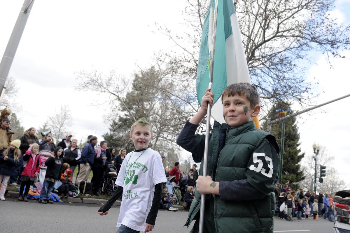 Johnny Symms, 9, carries an Irish flag and walks beside Braeden Welsh, 7, in the St. Patrick