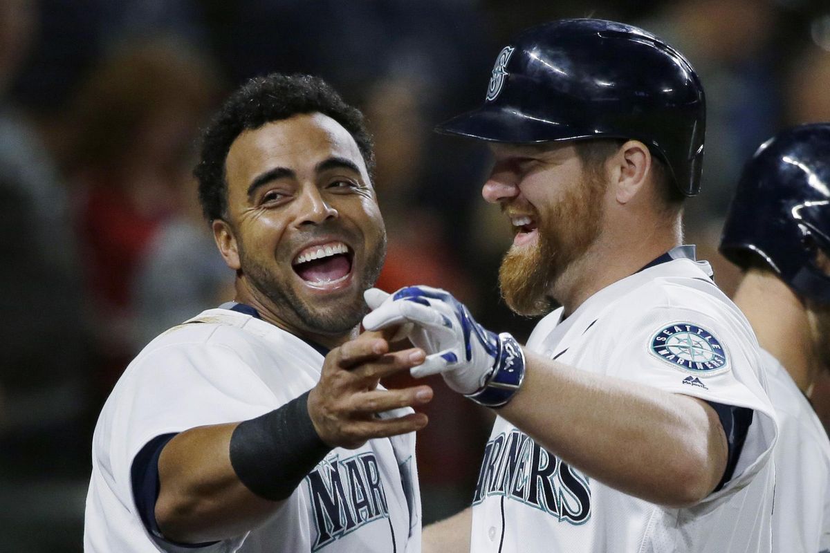 Mariners’ Nelson Cruz, left, reacts as he greets Adam Lind, right, after Lind hit a solo home run against the Baltimore Orioles during the sixth inning. (Ted S. Warren / Associated Press)