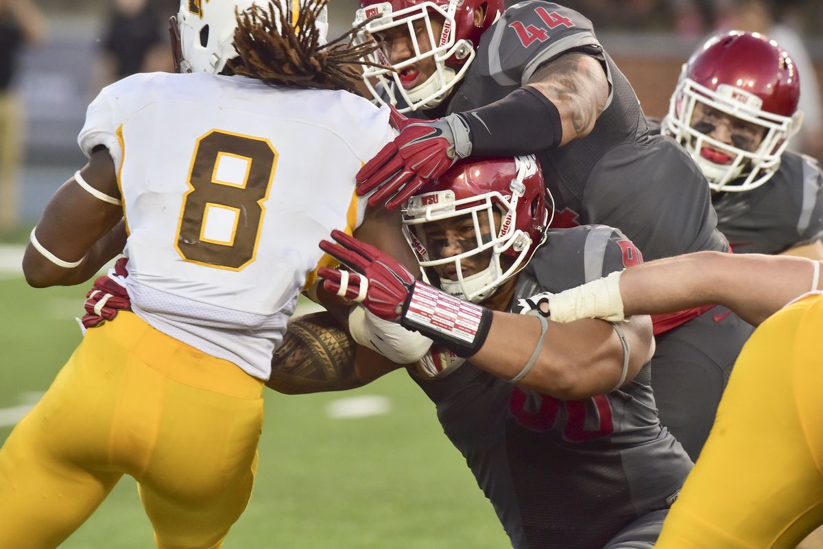 Wyoming running back Brian Hill runs into a wall of Washington State defenders during the first half of Saturday’s nonconference game at Martin Stadium. (Tyler Tjomsland)