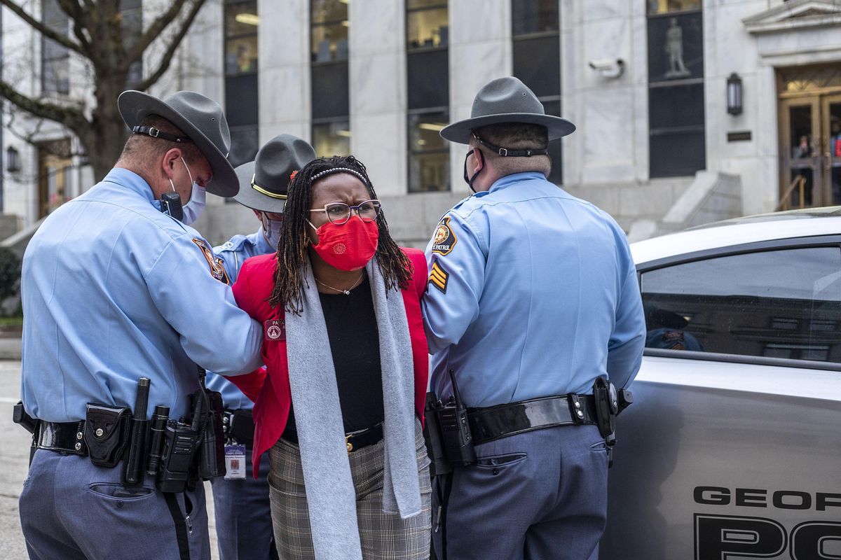 State Rep. Park Cannon, D-Atlanta, is placed into the back of a Georgia State Capitol patrol car after being arrested by Georgia State Troopers at the Georgia State Capitol Building in Atlanta, Thursday, March 25, 2021. Cannon was arrested by Capitol police after she attempted to knock on the door of the Gov. Brian Kemp office during his remarks after he signed into law a sweeping Republican-sponsored overhaul of state elections that includes new restrictions on voting by mail and greater legislative control over how elections are run.  (Alyssa Pointer)