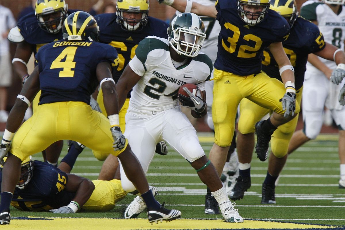 Michigan State running back Le’Veon Bell dodges a host of Michigan defenders on Saturday in Ann Arbor, Mich. (Associated Press)