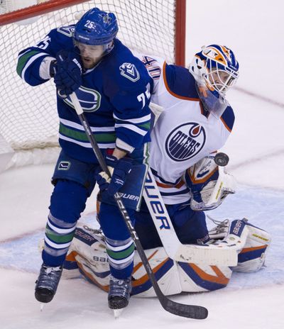 Vancouver Canucks center Andrew Ebbett tries to get a shot past Edmonton Oilers goalie Devan Dubnyk. (Associated Press)
