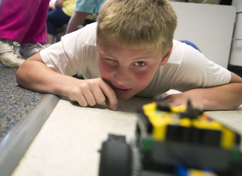 Broadway Elementary summer school student Connor Dehn, 9, keeps an eye on his computer-programmed Lego car as it heads to a target Thursday. (Colin Mulvany)