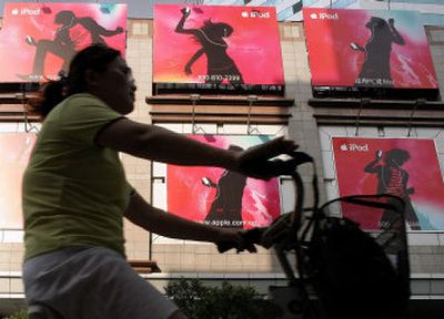 
 A woman rides a bicycle past iPod advertisements  earlier this month  in Shanghai, China. Apple Computer said Wednesday it was working to resolve a dispute over alleged labor abuses by an iPod manufacturer in China. 
 (Associated Press / The Spokesman-Review)