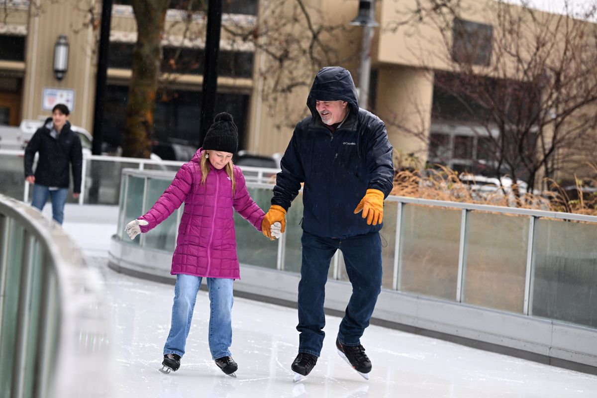 While shoppers were still scrambling for last-minute gifts, Butch Smith, right, takes granddaughter Savannah Kukuk ice skating Tuesday on the Numerica Skate Ribbon in Riverfront Park. Smith is visiting from Montana.  (Jesse Tinsley/THE SPOKESMAN-REVIEW)