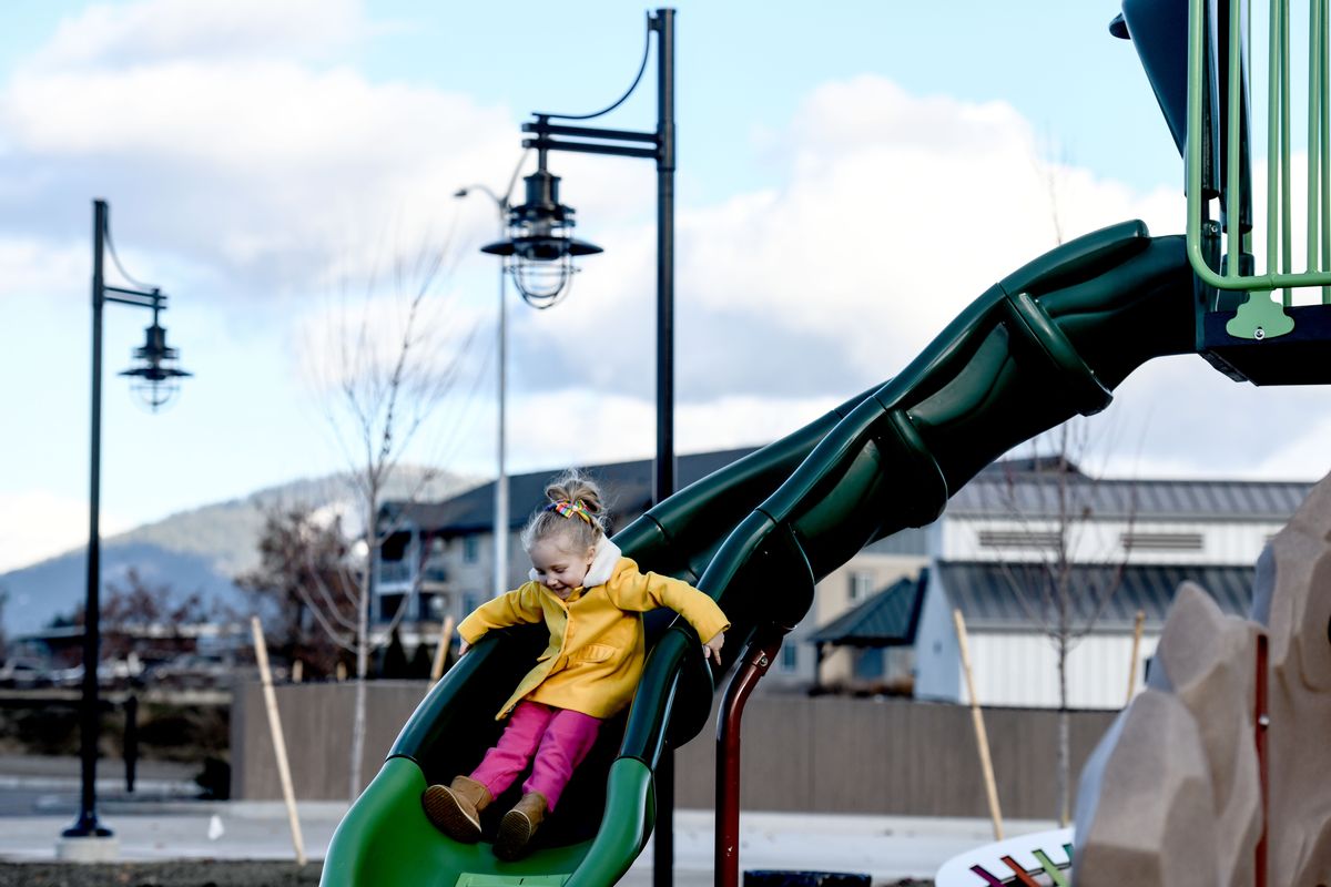 Five-year-old Emmy Colb makes use of a slide in the new park at the Atlas Waterfront Project near downtown Coeur d’Alene on Tuesday. The land was the former Stimson Mill site.  (Kathy Plonka/The Spokesman-Review)