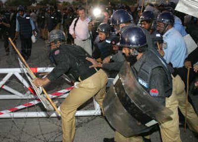 
Police officers replace a barrier that supporters of Benazir Bhutto tried to remove  during a protest Wednesday against Pakistan's President Gen. Pervez Musharraf in Islamabad, Pakistan. Associated Press
 (Associated Press / The Spokesman-Review)