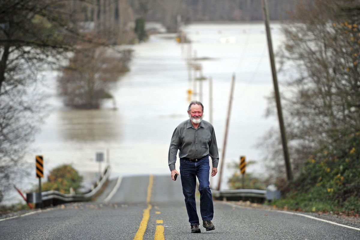 Chip Bergeron walks up the closed Francis Road after having a look at the flood waters from the nearby Skagit River in Mount Vernon, Wash. Officials say that flooding was worse than expected on the Skagit River north of Seattle. (Charles Biles / Skagit Valley Herald)