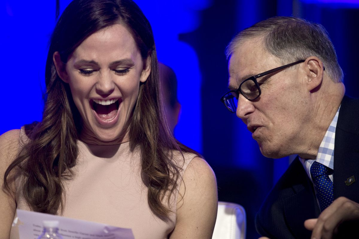 Actress Jennifer Garner and National Governors Association  Vice Chairman Washington Gov. Jay Inslee look at a document following Garner’s address to the NGA’s Winter Meeting in Washington, Saturday. Garner spoke about the need for early education. (Cliff Owen / Associated Press)