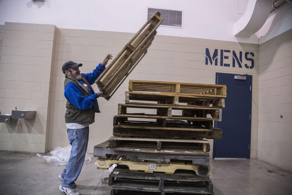Joe Kostelecky stacks pallets that held boxes of toys, Dec. 6, 2016, for the Christmas Bureau at the Spokane County Interstate Fair & Expo Center. (Dan Pelle / The Spokesman-Review)