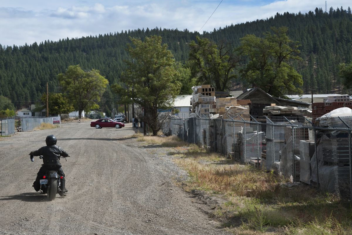 A motorcycle drives down unpaved East Central Avenue in The Yard, an industrial part of northeast Spokane that has sat polluted and largely abandoned for 50 years. (Dan Pelle)