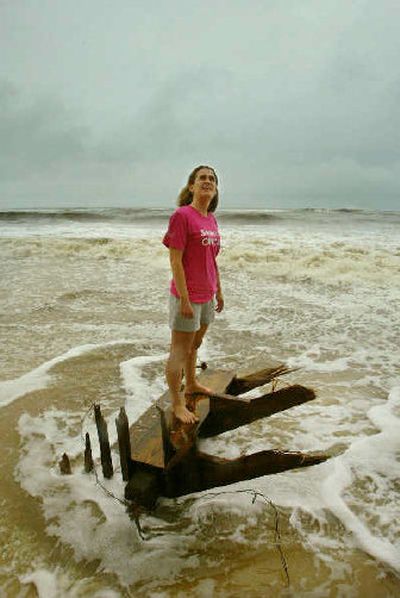 
A woman stands on remnants of the steps of her family's condo after water destroyed the deck staircase Saturday along a beach in Gulf Shores, Ala. 
 (The Spokesman-Review)