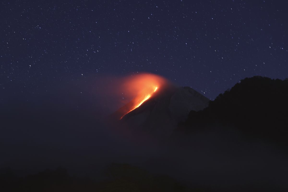 In this photo taken using slow camera shutter speed, hot lava runs down from the crater of Mount Merapi, in Sleman, Yogyakarta, Indonesia, early Wednesday, Aug. 11, 2021. The volcano is the most volatile of more than 120 active volcanoes in the country, and is one of the most active worldwide.  (Trisnadi)