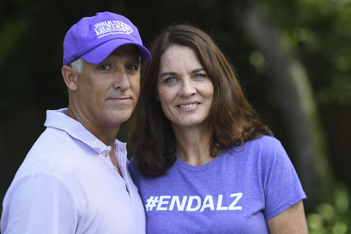 Michele Hall stands with her husband, Doug, in their backyard Thursday, June 24, 2021, in Bradenton, Fla. Hall, 54, diagnosed with early Alzheimer