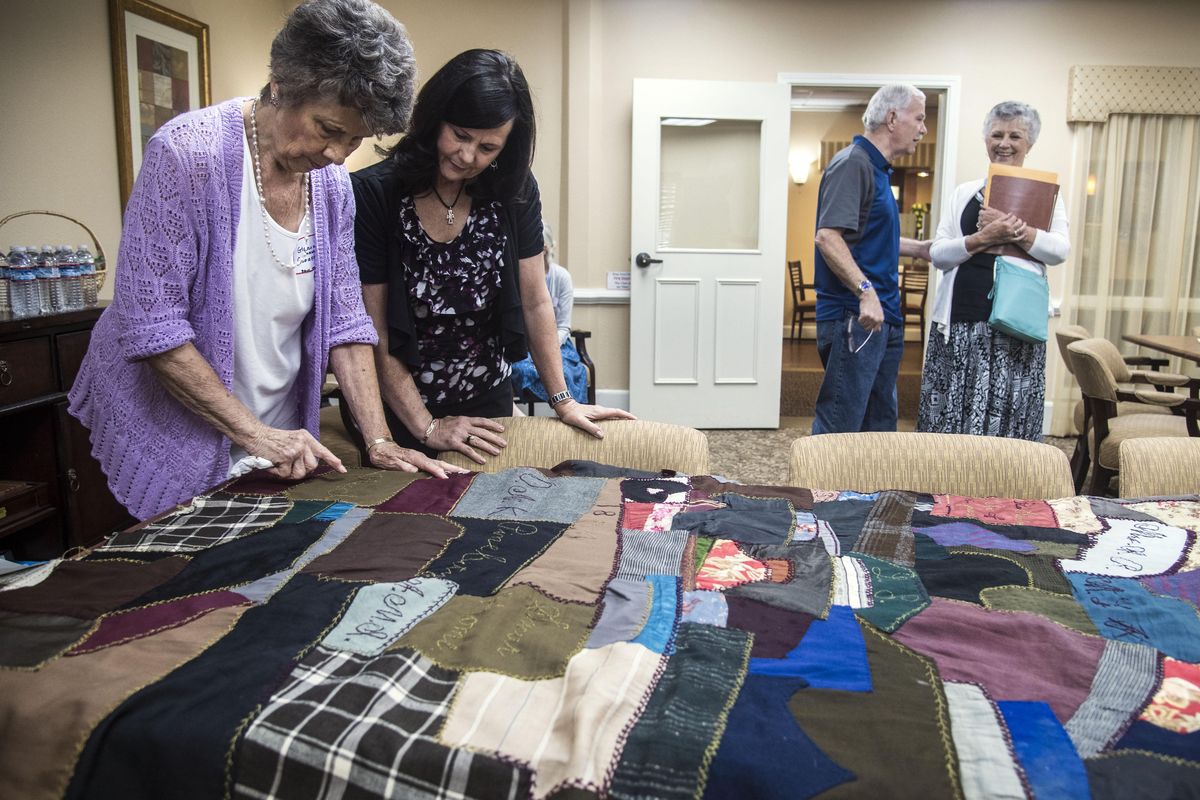 Gloria Glorfield, left, shows off a 123-year-old quilt to Sheri Taylor, as Mike Taylor talks with Patricia Dalton Mulethaler, Aug. 14, 2017, at a family reunion at Touchmark Senior Living in Spokane, Wash. (Dan Pelle / The Spokesman-Review)